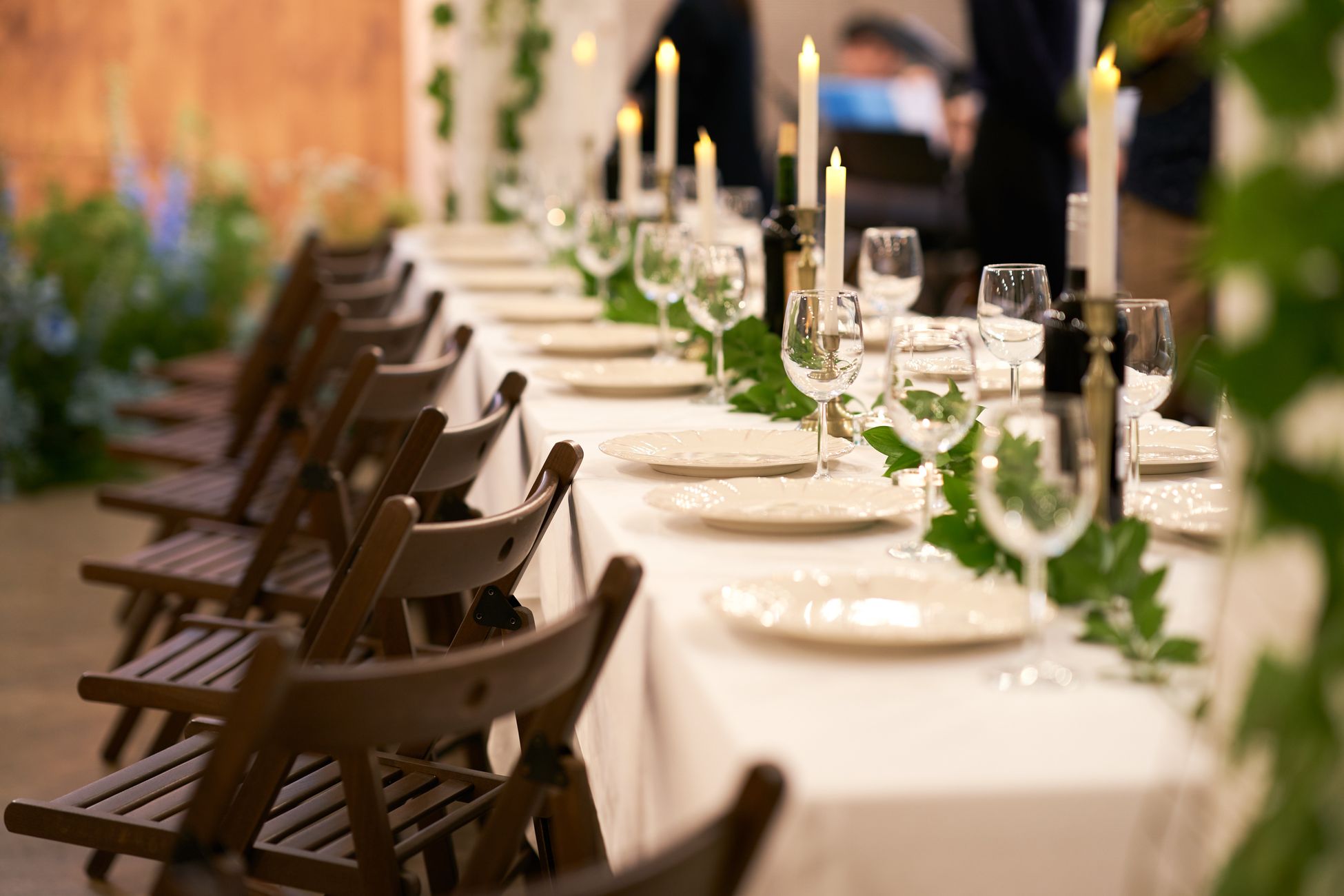 A beautifully decorated banquet table with candles and greenery, creating a warm and inviting ambiance.